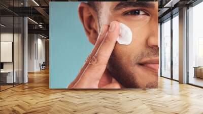 Portrait, beauty and cream with a man in studio on a gray background to apply antiaging facial treatment. Face, skincare and lotion with a young male person indoor for wellness or aesthetic self care Wall mural