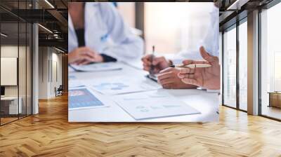 Team, medical analysts and doctors consulting with paperwork of graphs, data and charts in hospital conference room. Closeup of healthcare staff discussing statistics, results and innovation strategy Wall mural