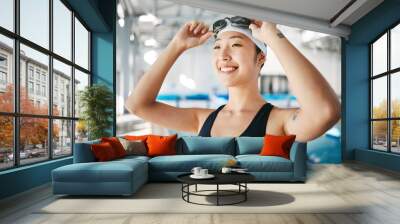 Professional swimming, asian woman with smile and goggles at pool for training, wellness and winner mindset. Water sports, workout and champion athlete swimmer at competition with smile and happiness Wall mural