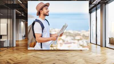 Journey, map and profile of man with backpack for travel, adventure and direction in Spain. Male tourist, smile and sight seeing in city for vacation, decision and route choice in summer for holiday Wall mural