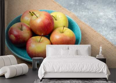 Blue bowl full of fresh apples on marble background Wall mural