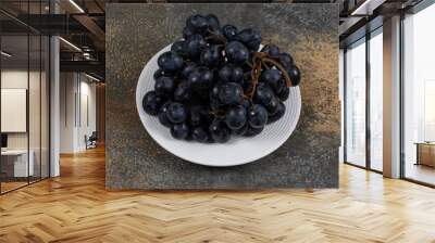 Cluster of black grapes on white plate Wall mural