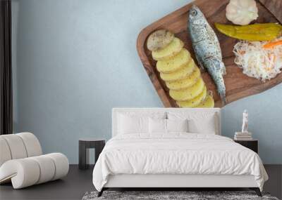 Herring, boiled potatoes and mixed pickles on wooden board Wall mural