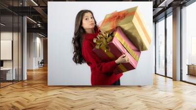 Pretty woman in red sweater holding two boxes of Christmas presents Wall mural