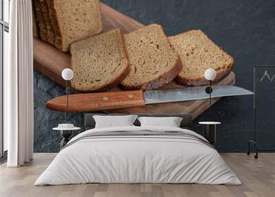 Slices of brown bread on a wooden board Wall mural