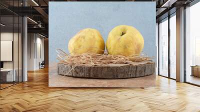 Two fresh quinces on wooden board with hay Wall mural