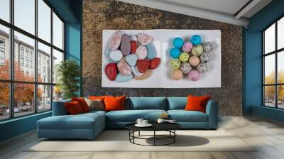 Two types of candies on white plate Wall mural