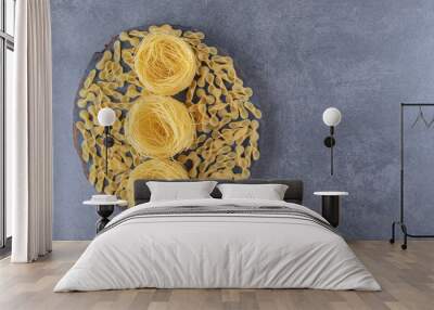 Two types of raw pasta on wood piece Wall mural