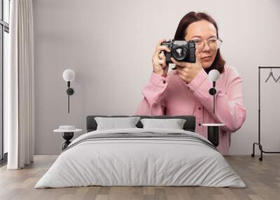 Woman taking a picture with camera on white background Wall mural