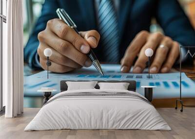 A businessman analyzes financial reports while using a pen to highlight key data in an office setting during the daytime. Generative AI Wall mural