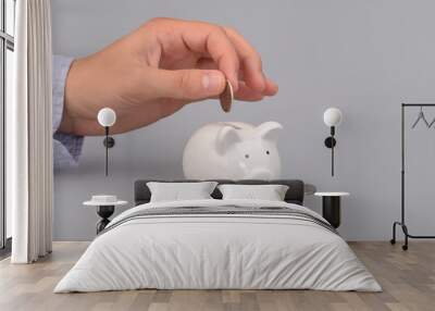 Hand holding coin. Piggy bank money savings concept Wall mural