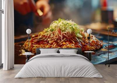 Close-up of okonomiyaki with green onions and sauce on a hot griddle. Wall mural