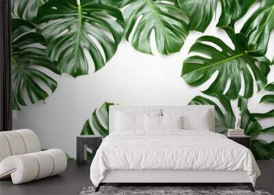 Green tropical leaves frame a blank space on a white background. Wall mural