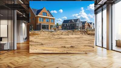 New construction homes with brown brick exterior and black tile roofs under a blue sky with white clouds, bare dirt in the foreground. Wall mural