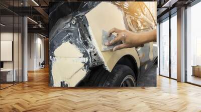 Repairing car body by puttying close up work after the accident by working sanding primer before painting. Wall mural