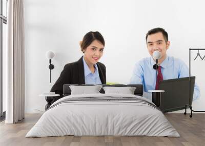 Young attractive confident Asian male business man and woman sitting on desk discussing work over coffee with laptop document on white background Wall mural