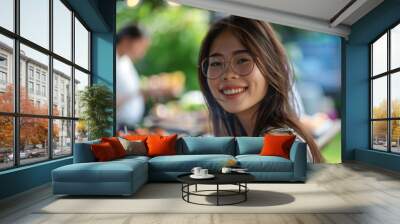 Portrait of a smiling young woman attending a barbecue Wall mural