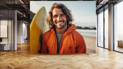 Smiling portrait of a happy male caucasian surfer on a sandy beach Wall mural