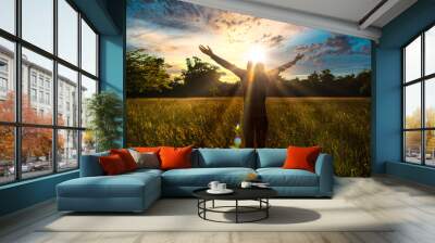 Young girl spreading hands with joy and inspiration facing the sun,sun greeting,freedom concept, nature lover ,spirit of forest Wall mural