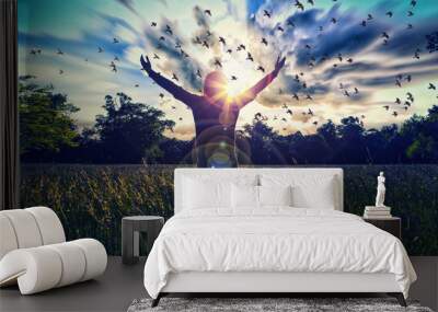 Young girl spreading hands with joy and inspiration facing the sun,sun greeting,freedom concept,bird flying above sign of freedom and liberty Wall mural