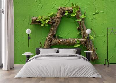 A green wall with a letter A made out of branches and leaves Wall mural