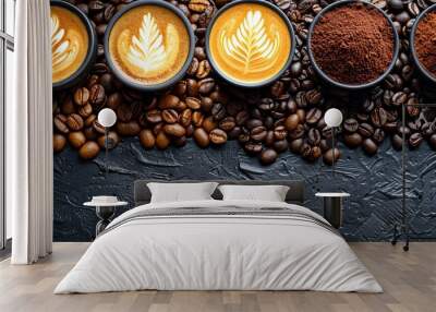 A close-up shot of various coffee beans and cups of cappuccino with latte art on a textured black background. Wall mural