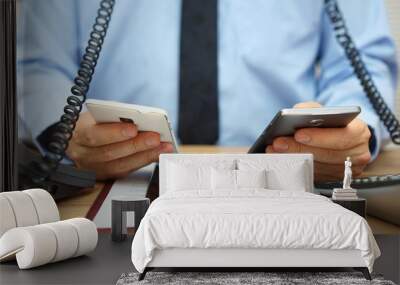 busy businessman in office at the desk using two mobile phones, Wall mural