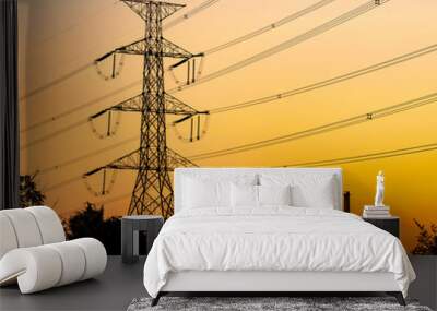 High-voltage towers of the city and the sky are orange light of the sun. Wall mural