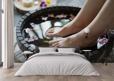 Woman relaxing with a foot bath with flowers. Wall mural