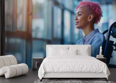 Happy smiling disabled office LGBTQ+ queer female sitting on wheelchair next to office window looking outside, pink lesbian afro hair, bright diverse positive workplace, candid afro american Wall mural