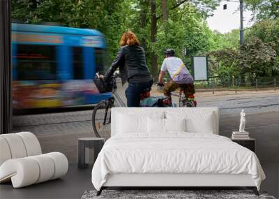 Cyclists wait while the tram passes. Krakow, Poland. Wall mural