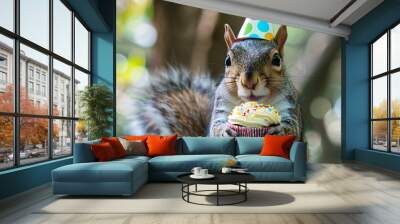 A cheerful squirrel wearing a party hat holds a cupcake, celebrating in a vibrant outdoor setting. Wall mural