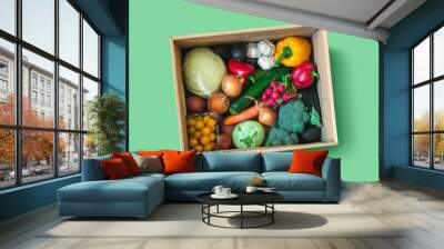 Fresh vegetable delivery box on green background Wall mural