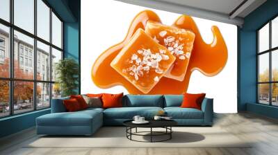 Two salty or salted caramel candy cubes topped with caramel sauce and sea salt on white background Wall mural