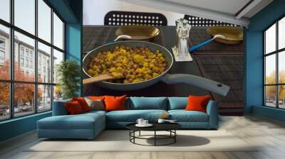 pan with chickpeas and potatoes traditional dish from canary island. 2 dishes with a blue spoon and black table with blach chairs Wall mural