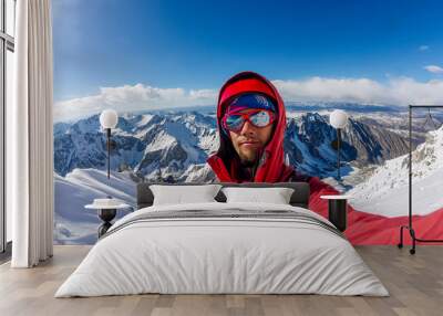 Selfi male mountaineer in snowy mountains, wearing a helmet with a backpack Wall mural