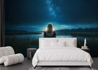 A beautiful young blonde woman is standing waist-deep in water, with her back to the viewer, evening and night starry sky fantastic illustration Wall mural