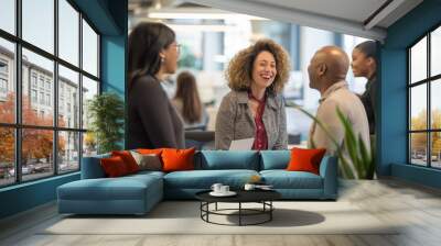 A diverse group of colleagues laughs and collaborates in an open office Wall mural