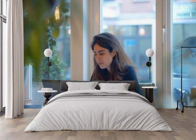 A young professional woman is working on a laptop in a modern office Wall mural