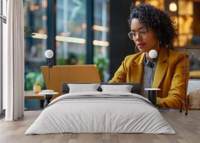 A young professional woman is working on a laptop in a modern office Wall mural