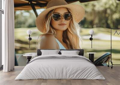 Young woman enjoying a sunny day on the golf course while driving a golf cart in a stylish outfit and sunglasses Wall mural