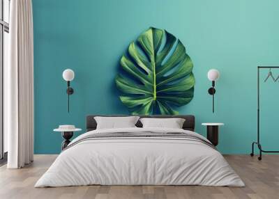 A minimalist vector art of a tropical leaf, bold shapes, and vibrant colors, positioned centrally on a solid pastel blue background Wall mural