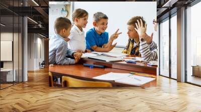 A kind female teacher spends time with her elementary school students, making learning enjoyable and fun while sparking curiosity and fostering a love for education. Wall mural