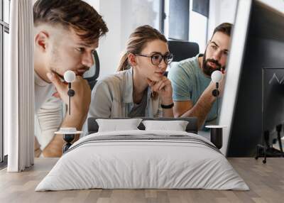 Group of programmers  discussing about new project.They looking at the computer screen and testing the code.Developing new software. Wall mural