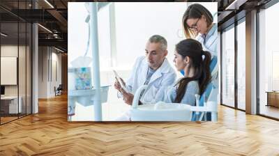 In a busy dental office, a group of dentists examining x-ray image of the patient's teeth to provide accurate diagnoses and develop effective treatment plans. Wall mural