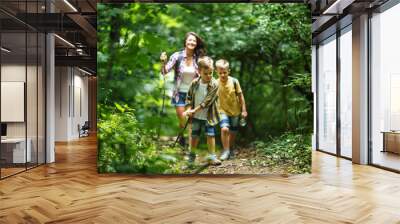 Mother and her little sons  hiking trough forest . Wall mural