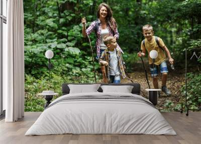 Mother and her little sons hiking trough forest .Outdoor spring leisure concept.	
 Wall mural