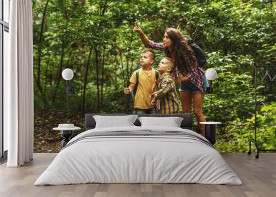 Mother and her little sons  hiking trough forest .Watching birds. Wall mural