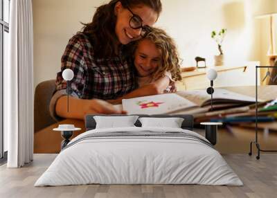 Mother helps her daughter to draw with colored pencils.	
 Wall mural