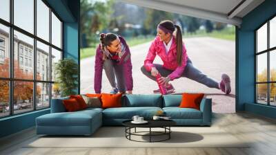 Two attractive female exercising  outdoor.Stretching. Wall mural